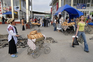 A woman selling bread from a stall in the street.