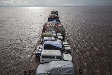 With its deck loaded with vehicles and cargo, a ferry boat leaves the port of Kinshasa at the start of its journey up the Congo River to Kisangani.