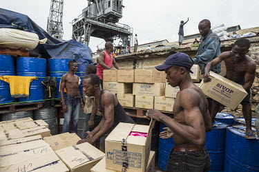 Porters loading cargo onto a ferry boat moored in a harbour on the Congo River. The boat will sail upstream towards Kisangani.