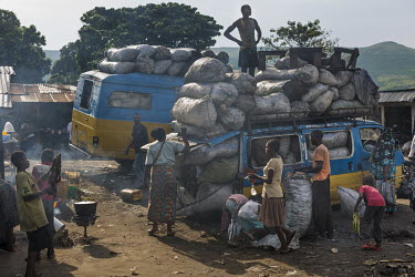 Men craming vans with sacks of charcoal brought from the interior of the country.
