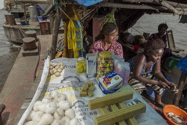 A woman waits for customers on the stall she has set up on a vessel sailing up the Congo River.