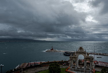 A view from the city of the Bay of Naples, the Tyrrhenian Sea and the Vesuvio volcano, covered in heavy clouds.