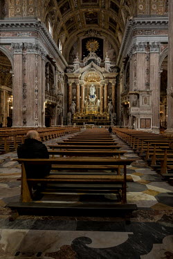 A man sits in the almost empty Gesu Nuovo church.