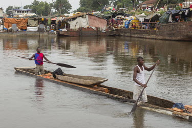 Two men paddle a canoe (pirogue), overloaded with a cargo of bricks, along the Congo River. Later the canoe sunk.