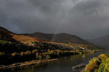 A rainbow appears above the River Douro and the hillside vineyards.
