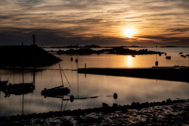 The sunsets over the harbour basin at low tide.