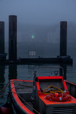 A mooring and a boat in the misty harbour basin.