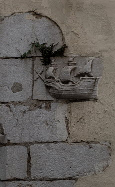 A plaque depicting a sailing vessel on a wall in the Moorish quarter of Alfama.