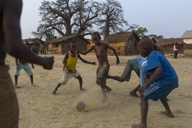 A group of boys kick around a ball they fashioned themselves using old plastic bags.