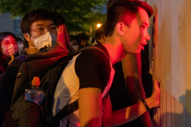 Protsters peer through a metal fence at a demonstration in central Hong Kong. An estimated two million demonstrators poured onto the streets of Hong Kong to protest peacefully against the government's...