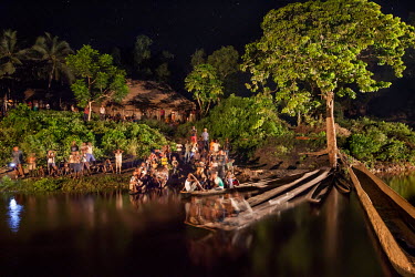 Villagers wait impatiently for the barge that will bring family members and news from the outside world.