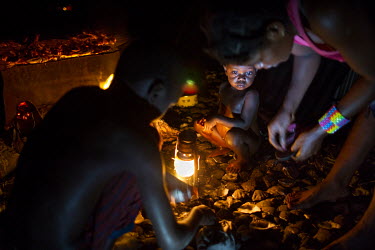 A family living on Kimwabi Island in the Congo River estuary prepare and cook clams caught in the surrounding waters. The national park is a veritable maze of islands and channels where the main activ...