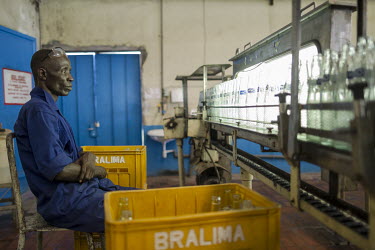 A worker carries out quality control checks at a Bralima factory where beers and soft drinks are produced. The facility, owned by Heineken, was closed due to its lack of profitability.