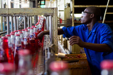 A worker carries out quality control checks at a Bralima factory where beers and soft drinks are produced. The facility, owned by Heineken, was closed due to its lack of profitability.