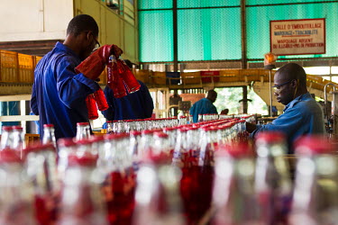 Workers carry out quality control checks at a Bralima factory where beers and soft drinks are produced. The facility, owned by Heineken, was closed due to its lack of profitability.