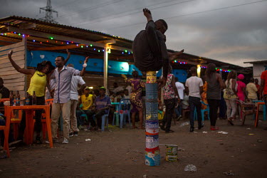 A contortionist tries to make a bit of extra money in a makeshift entertainment zone on the banks of the Congo river. The river banks are popular with Kinshasa's population, or Kinois, who come here t...