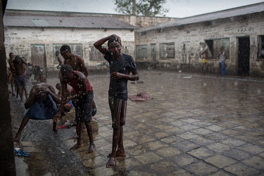 Prisoners take the opportunity of a torrential rain shower to wash in the yard of the prison. For many prisoners, rain can be the only source of water to wash in. Many wait for months in the jails bef...