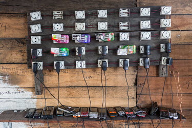 Mobile phones are charged in a local shop. Only six per cent of Congo's population have access to regular electricity so many mobile phone users come to shops to charge their devices.
