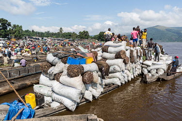 People gather to unload a boat laden with charcoal that has arrived from the interior of the country in the small port of Maluku, north of Kinshasa. Kinshasa consumes around five million cubic metres...