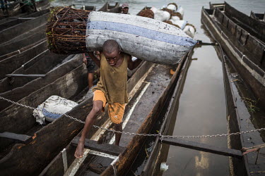 A porter unloads a boat laden with charcoal that has arrived from the interior of the country in the small port of Maluku, north of Kinshasa. Kinshasa consumes around five million cubic metres of char...