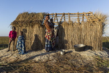 A woman and her children in front of their temporary dwelling. During the fishing season the population in the region rapidly swells as temporary fishing settlements are established.
