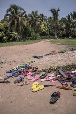 Flip-flops belonging to vanilla workers lie scattered on the ground at the entrance to a warehouse owned by food products company Virginia Dare.
