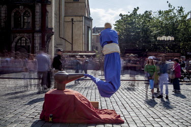 A street perfomer does an 'Aladdin and the magic lamp' routine in front of a crowd in the Old Town Square.