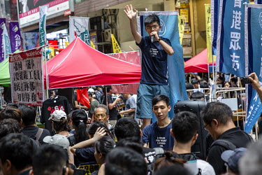 Student activist Joshua Wong, wearing a t-shirt with the slogan: 'I stand for what I stand on', speaks to the crowds in Causeway Bay during mass demonstrations against the extradition bill, police use...