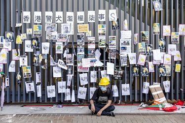 A lone protestor sits beside a wall covered in notes lefts by activists as a huge march took place against the extradition bill, police use of force during protests and to demand Chief Executive Carri...