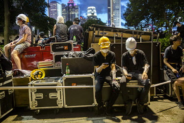 Activists sit with their sound equipment as night falls following a huge demonstration against the extradition bill, police use of force during protests and to demand Chief Executive Carrie Lam's resi...