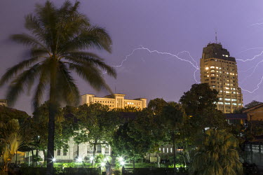 Lightning illuminates the sky around the Sozacom building on Boulevard du 30 Juin during a rainy season storm in the capital.