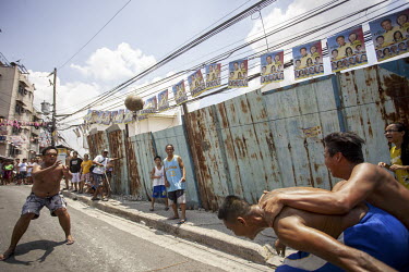 Men playing a version of rugby in the street using a fresh coconut as a ball.