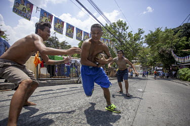 Men playing a version of rugby in the street using a fresh coconut as a ball.