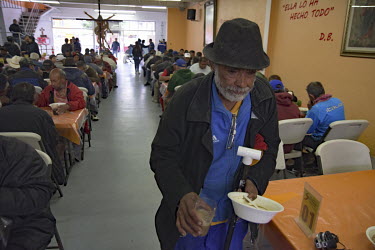 A man carries a plate after eating at the Desayunador de Padre Chava, a facilty provided by the Catholic Church where the homeless, migrants and urban poor are offered a free breakfast and social serv...
