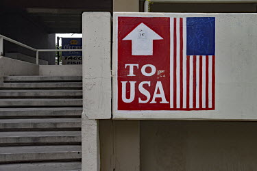 A sign in the form of an American flag reads: 'To USA', at the Desayunador de Padre Chava, a facilty provided by the Catholic Church where the homeless, migrants and urban poor are offered a free brea...