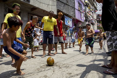 Children playing a version of rugby in the street using a fresh coconut as a ball.