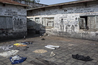 Clothes dry on the floor of a courtyard in Kasongo's prison, where graffiti covers the walls of its buildings.