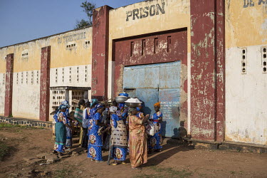 A group of women from a local church, who come each month to help inmates with food and medicines, wait to enter outside the walls of Kasongo's prison.