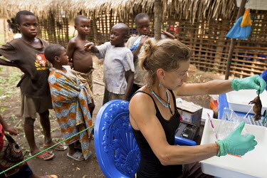 While children watch, the Belgian biologist Anne Laudisoit conducts field research into diseases such as the plague and Ebola.