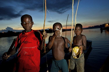 A group of children show the fish they've caught from the Congo River using bamboo rods.