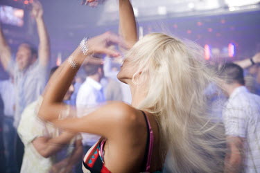 A woman with blonde hair dances at Club Essential.