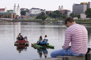 On a summer's evening, people gather on the Svislach River waterfront where they drink vodka and beer and take paddle boats out for a ride and watch the sunset.