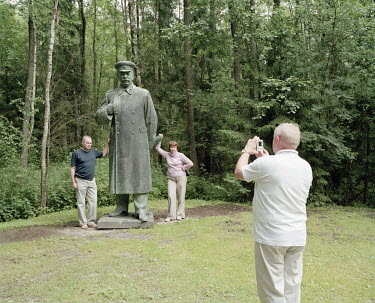 A couple have their photograph taken while standing beside a giant Stalin statue in Grutas Park. The sculpture garden of Soviet-era statues and displays of other ideological relics, was founded by the...