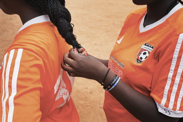 A group of refugee girls, from the Democratic Republic of Congo (aged between 10 and 14 years old), listen to their coach before they play a short football match. During the training the coach passes...