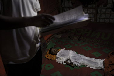 A police officer fills in an accident report after the death of five year old Rohingya refugee Ibrahim who was playing near a flooded canal with some friends in the refugee camp where they live when h...