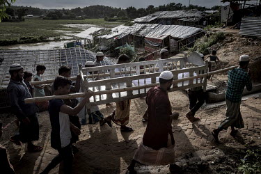 Family members carry the body of Ibrahim, a five year old Rohingya refugee boy, for burial. The boy was playing near a flooded canal with some friends when he fell into the fast following stream. The...