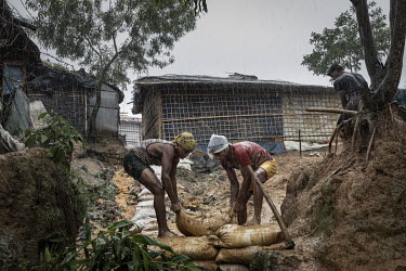 Rohingya refugees use sandbags to try and stop flood waters from breaching their shelters. In early July 2019, the monsoon rains arrived with four days of continuous rain that destroyed 273 shelters a...