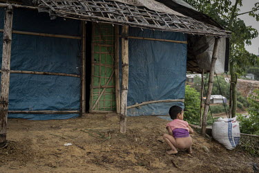 A Rohingya refugee child defecates outside a shelter in Camp 18 at Kutapalong mega camp. 98% percent of households reported that adult household residents 'usually' defecate in a latrine, with 6% â��...
