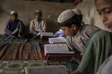 Rohingya refugee children reading Korans at a madrassa in Camp1W in the Kutupalong extension site where 270 children study seven subjects, all of them with a religious theme. Madrassas have emerged as...
