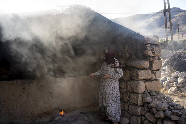A Kurdish woman preparing a clay bread oven in a village doomed to disappear beneath an artificial lake as a result of the Ilisu hydroelectric dam project.